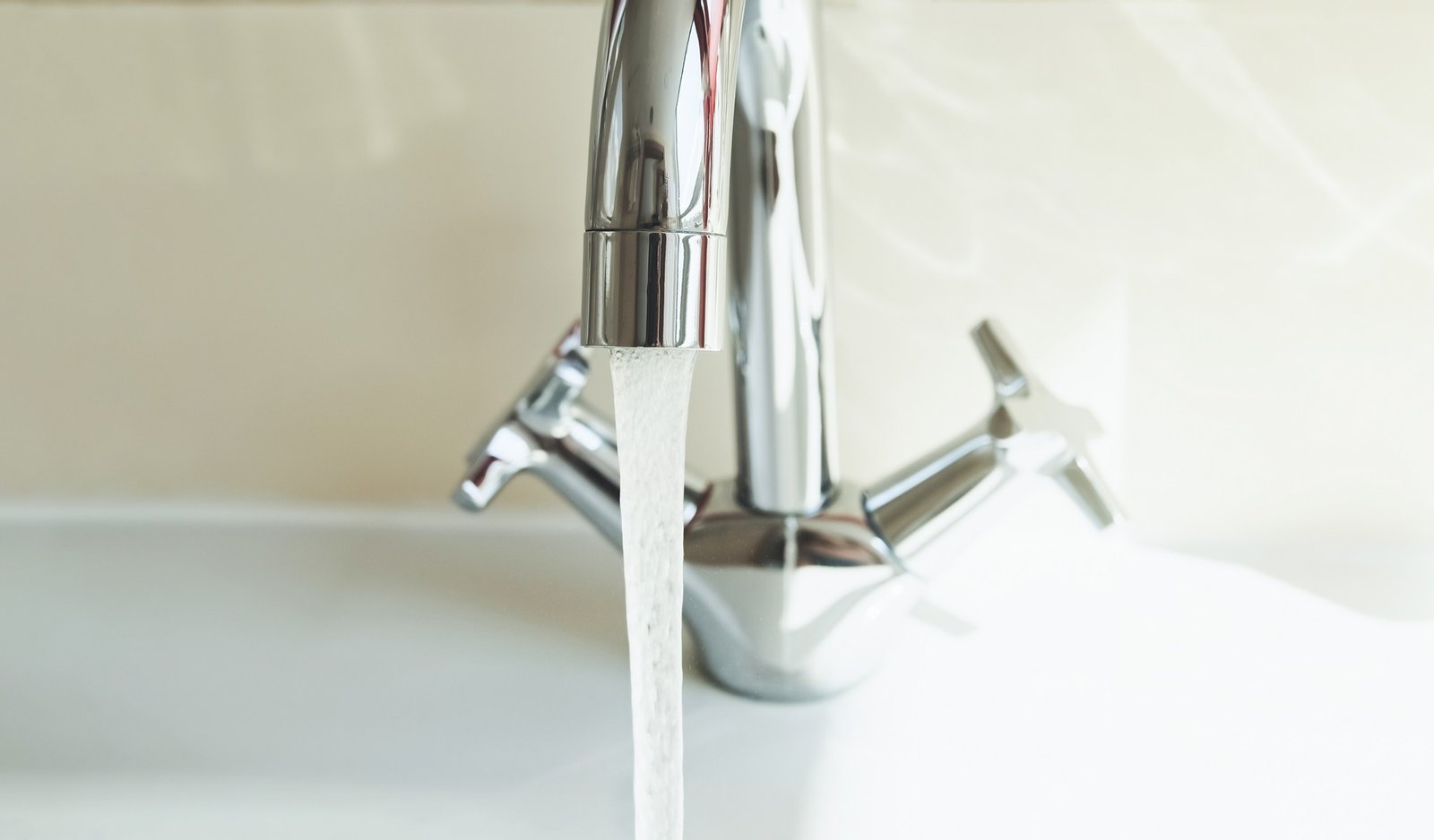 Kaltes Wasser läuft über einen Fleck auf Stoff